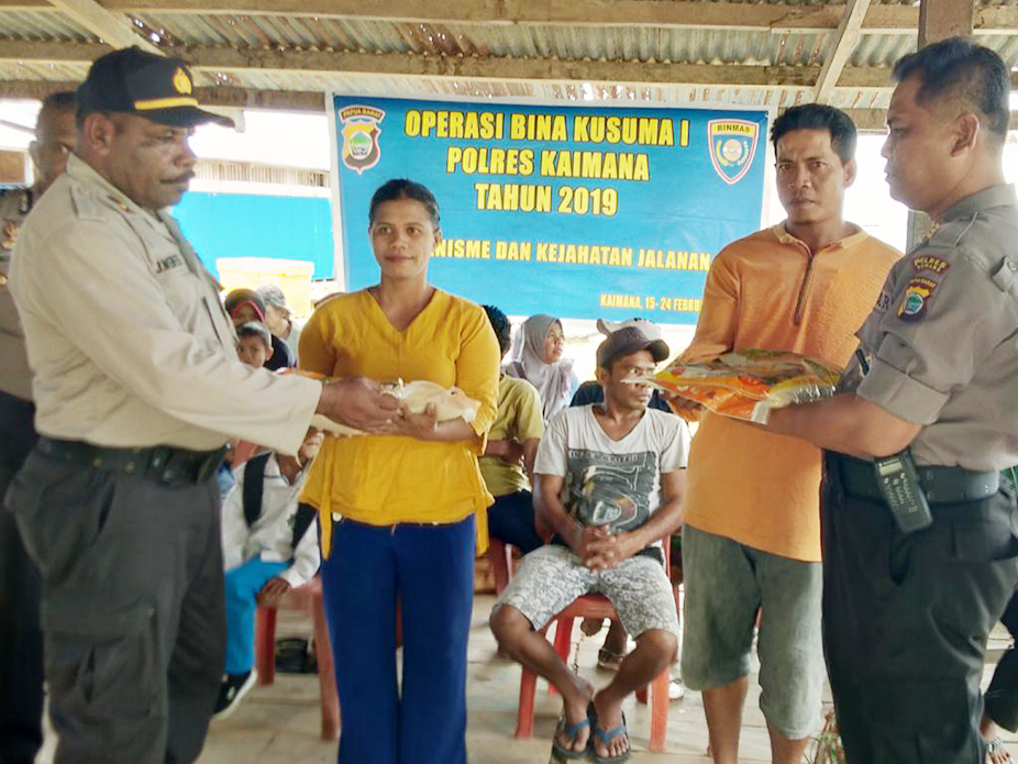 Kasat Binmas Polres Kaimana Saat Menyerahkan Bantuan kepada Warga Kaki Air Besar, dalam Operasi Bina Kusuma 2019
