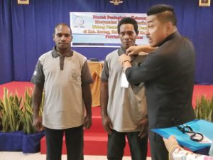 Anggota DPR RI DR. Michael Watimena saat memasang tanda peserta Bimtek kepada Nelayan yang mengikuti Bimtek tersebut